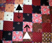 Two pucks moving on a square quilt top. Quilt Hopper design by Ken Young, construction by Jo Anne Young.