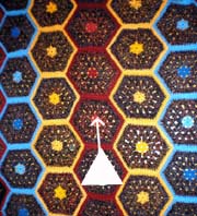 A puck moving on a hexagon afgan. Quilt Hopper design by Ken Young, construction by Jo Anne Young.